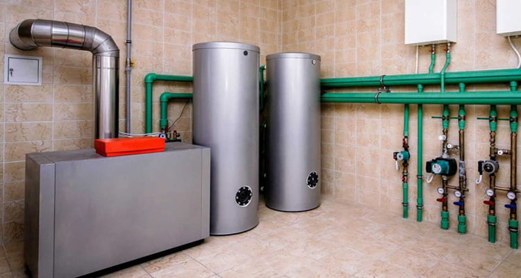 Two hot water tanks and a couple tankless hot water heaters visible in a room.